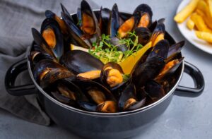 Delicious seafood mussels with parsley sauce and lemon. Delicious steamed mussels.