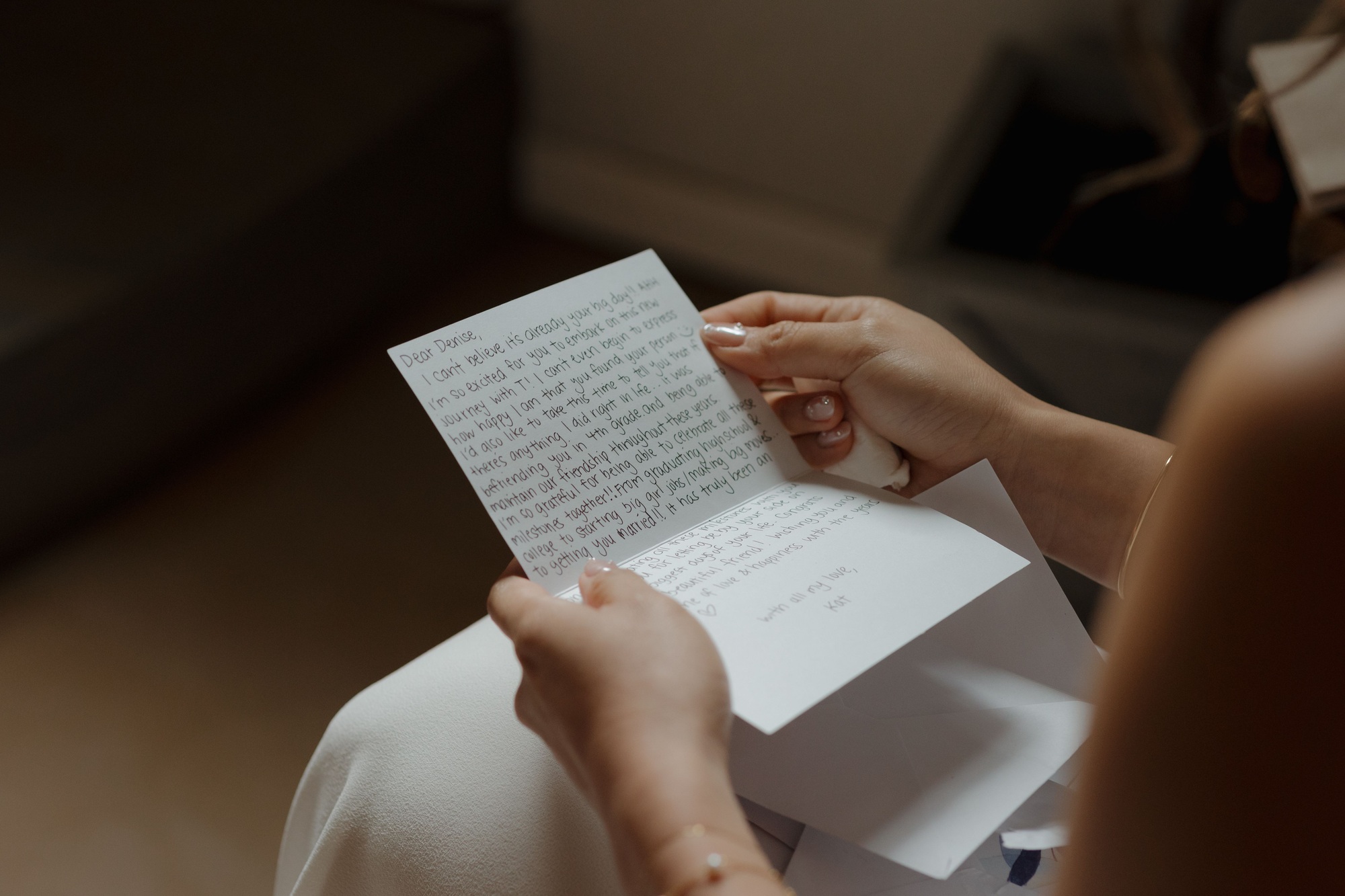 Closeup scene of an emotional moment of a bride reading a letter from her friend in her wedding day.