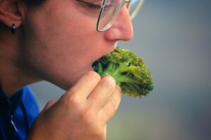 Closeup of a woman eating broccoli