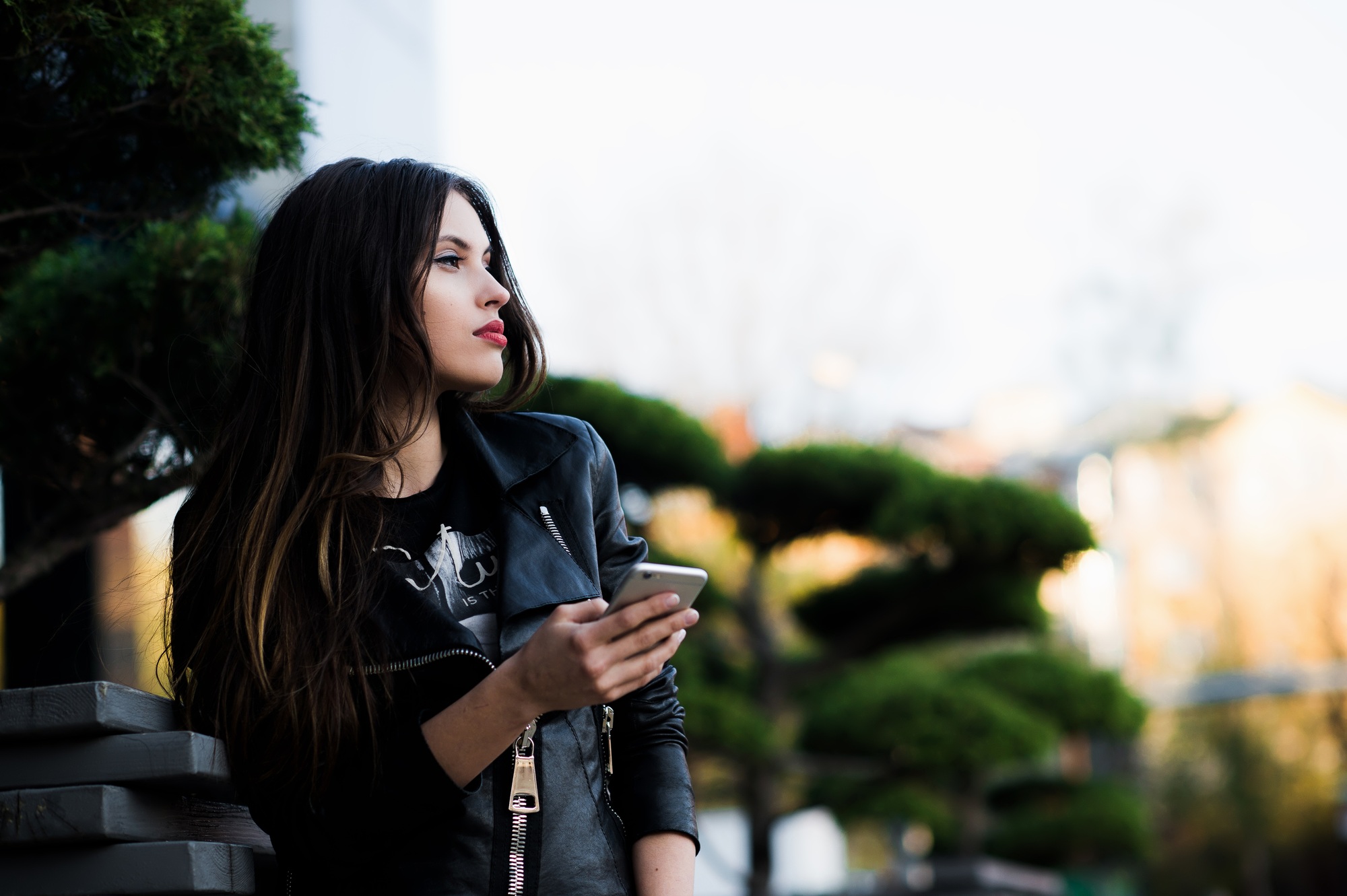 Young beauty woman writing message on cell phone in a street cafe. Looking down